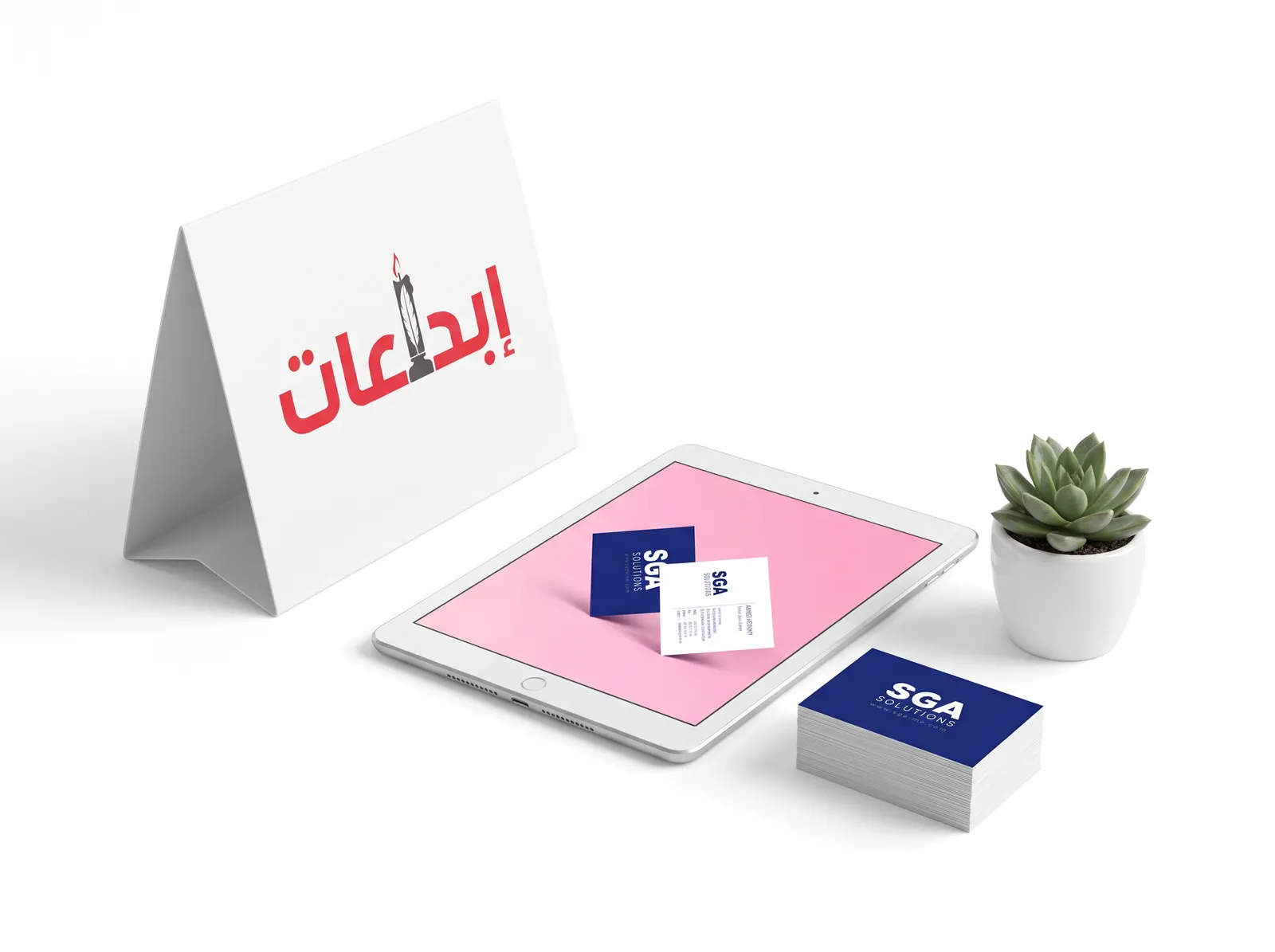 ستاند عرض يحمل شعار إبداعات بجوار جهاز لوحي يعرض أحد أعمالنا وكروت شخصية